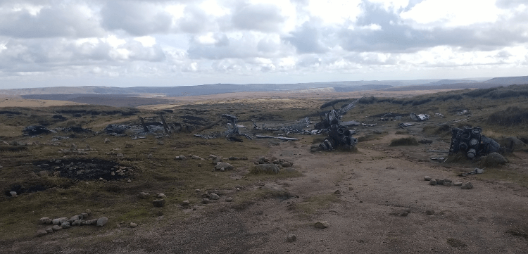 Wreckage from the plane crash is scattered across an expanse of moorland.